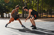 © Harry Rendón - two young men playing basketball outdoors fight for the ball
