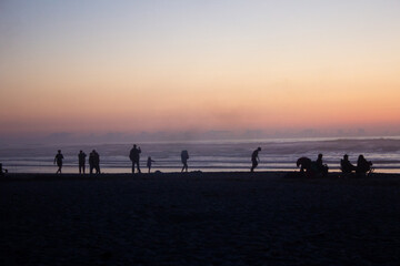 people on the beach at sunset