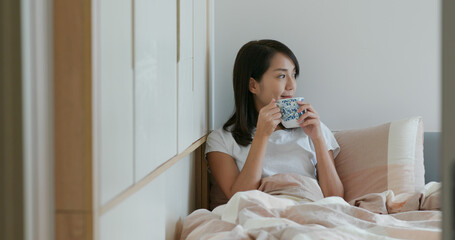 Wall Mural - Woman drink of water on bed