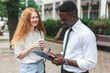 © vladdeep - Black african american man on the street making a survey to redhaired woman