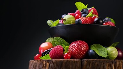 Wall Mural - Mix of wild berries on black background, collection of strawberry, blueberry, raspberry and blackberry, 4K UHD video footage