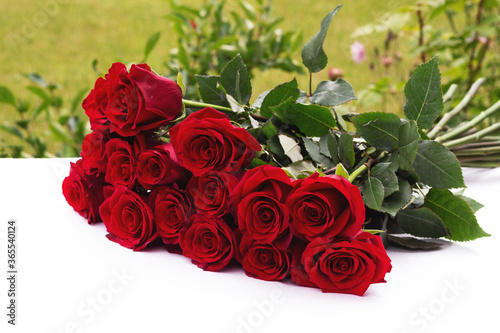 bouquet of red roses in the garden on the table. Congratulations on the holiday © Irina