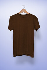 Brown T-Shirt on a hanger against a light blue background