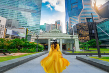 Asian Woman Into Raffles Place With Ocean Financial Centre, Republic Plaza And Mrt Station Entrance In Singapore