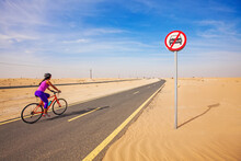Car Free Day And A Woman Riding Bicycle In A Desert In Dubai