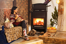 Woman Next To The Fireplace With Her Pet Animal
