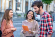 © zinkevych - Cheerful three friends with a tablet on the street