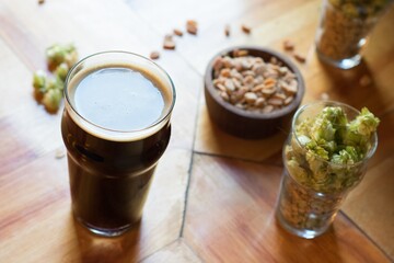 Sticker - High angle shot of a glass of beer next to peanuts, pine nuts, and Brussels sprouts