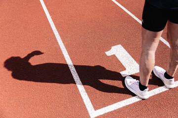 Man shadow on the number one on the running track as the starting position.