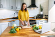 © Vadim Pastuh - Cheerful young woman cooking with a movie. A girl prepare salad, slices a vegetables and looks at the laptop screen