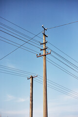 Closeup of old power poles on a clear summer day.