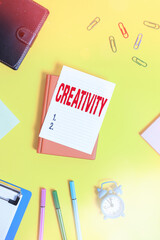 Poster - Conceptual hand writing showing Creativity. Concept meaning the imagination of original ideas in particular in the creation of art Pile of empty papers with copy space on the table