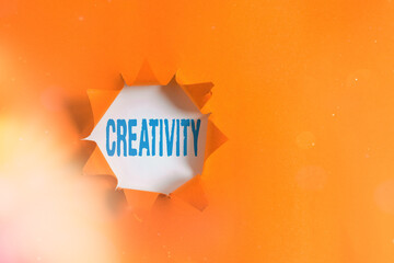 Poster - Text sign showing Creativity. Business photo text the imagination of original ideas in particular in the creation of art Rolled ripped torn cardboard placed above a wooden classic table backdrop