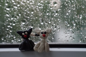 Sticker - Figures of two cats on the background of a wet window.