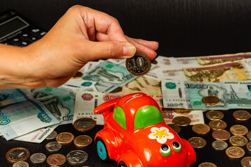 Wall Mural - girl puts money in a piggi bank