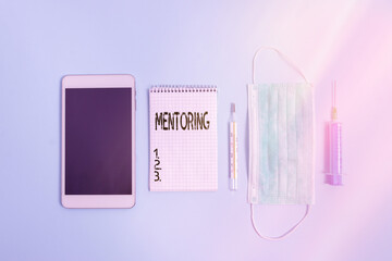 Writing note showing Mentoring. Business concept for an act or method of supporting and giving advice to a younger Set of medical equipment with notepad for health condition assessment