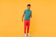 © Look! - Full-length portrait of stylish african guy in white sneakers. Glad brunette man standing in confident pose on yellow background.