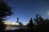 Fototapeta  - Ja i mój aparat na statywie podczas sesji fotograficznej komety C/2020 F3 NEOWISE, na brzegu jeziora o poranku