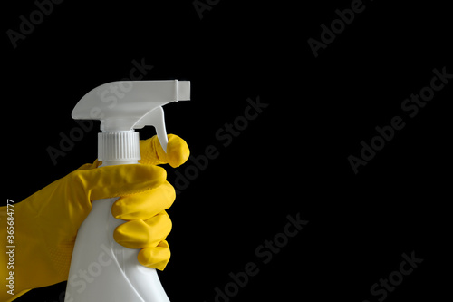 Fotografía Person in gloves spraying detergent on black background, closeup