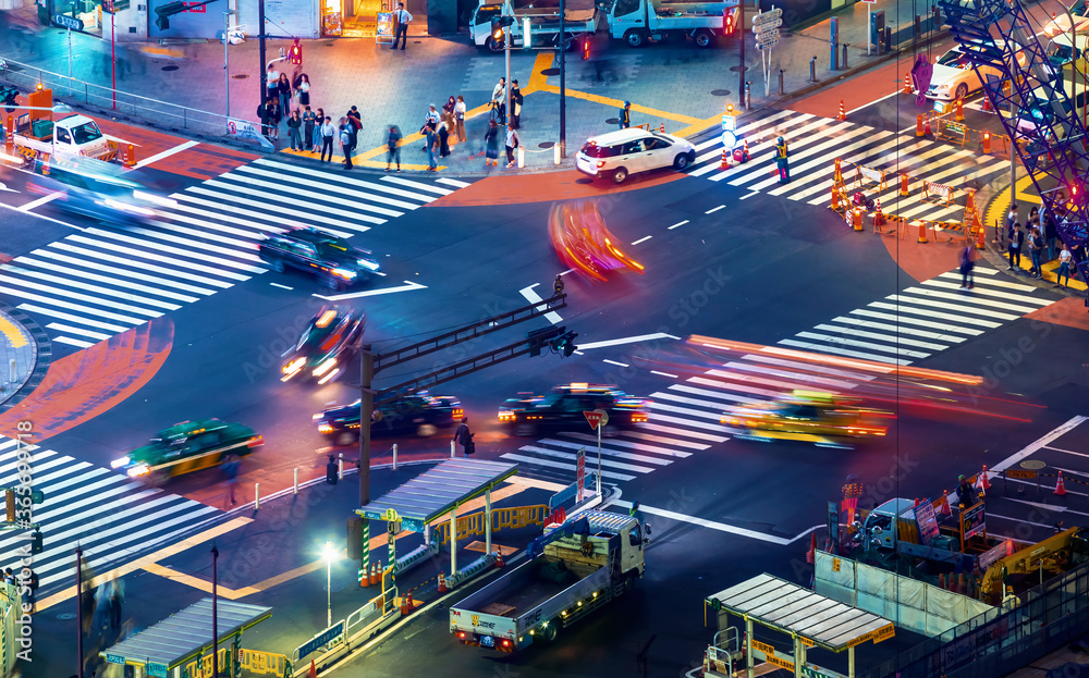People and traffic cross the famous scramble intersection in Shibuya, Tokyo, Japan, one of the busiest crosswalks in the world
