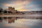 Fototapeta  - Victorian architecture of the Scarborough hotel reflected on the beach as the tide comes in at sunset