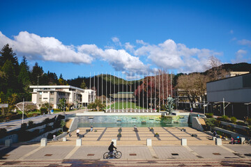 People walking and biking at the central square of the campus of the University of Concepción in a sunny day