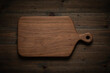 Handmade walnut wood chopping board on dark wood table, walnut wood chopping board texture background.