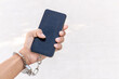 Smartphone chained to handcuffed in hand. Mobile phone addiction concept.