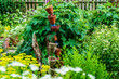 arangiertes Gartenidyll mit Blumentöpfen; üppiger, opulenter, blühender Bauerngarten im Allgäu, Bodenseehinterland mit Rosen, Stauden, Beeten