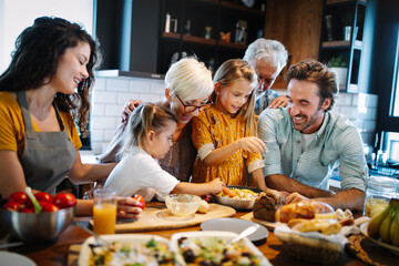 Cheerful family spending good time together while cooking in kitchen