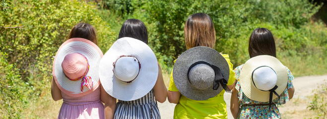 group of young girls walking on the road with straw hats