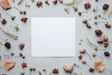 Poster - Autumn greeting card, thanksgiving day. White mockup paper sheet with foliage decoration on stone background. Copy space, flat lay