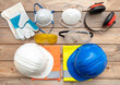 © Rawf8 - Work safety protection equipment on wooden background.