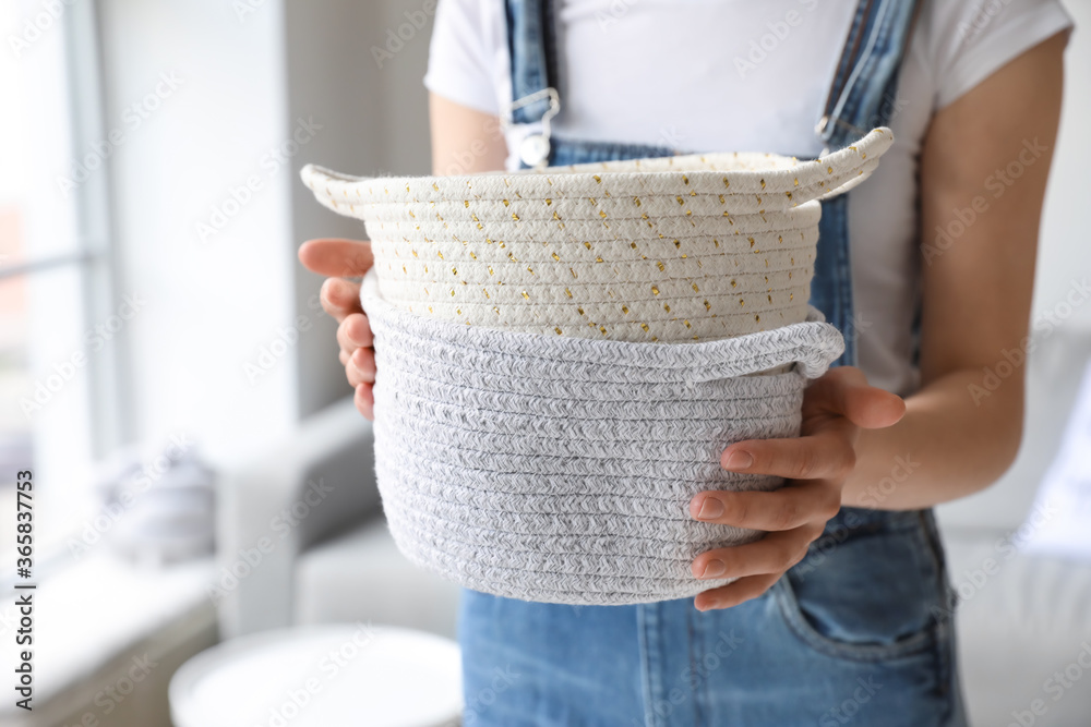 Woman holding wicker baskets in room