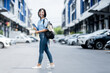 © Pixpan - Young Asian girl wearing face shield walking in the city with smartphone in her hand