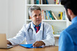 Leinwandbild Motiv Attraktiver Arzt spricht mit einem Patienten