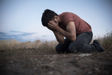 man hand in face in field