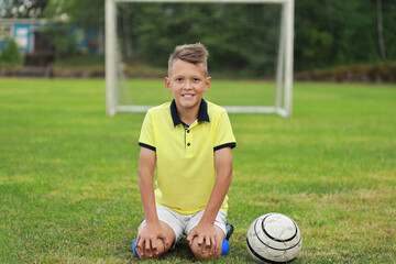 Aufkleber -  boy football player in a yellow t-shirt sits on the football field