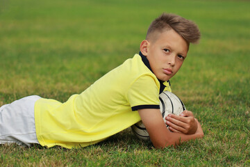 Aufkleber -  boy soccer player lies on the soccer field with the ball