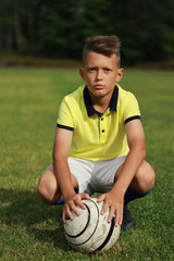 Aufkleber - handsome boy soccer player in a yellow t-shirt on a soccer field with a ball