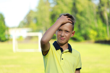 Aufkleber - boy football player stands in a yellow T-shirt stands on the football field.