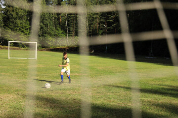 Aufkleber -  boy soccer player in a yellow t-shirt on the soccer field plays with a ball