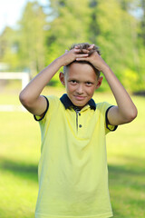 Aufkleber - boy football player stands in a yellow T-shirt stands on the football field.