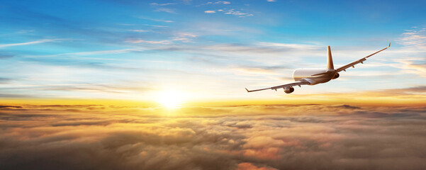 commercial airplane flying above clouds