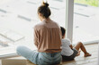 © Olena Bloshchynska - Mother and son sitting on the floor near the window.