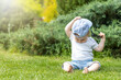 © frank11 - Little boy is taking off his hat holding sunglassesand sitting in the garden