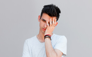 Closeup portrait of a groggy upset worried sad, depressed, tired business man with a headache and very stressed hand in hair, isolated on white background, Negative human emotion facial expression