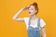 © ViDi Studio - Shocked young readhead girl in casual denim clothes white t-shirt isolated on yellow background studio. People lifestyle concept. Mock up copy space. Hold hand at forehead looking far away distance.