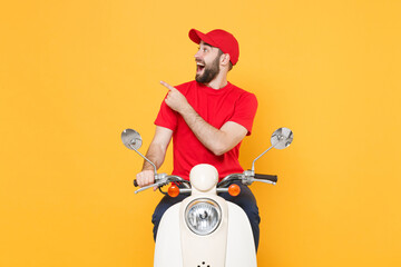 Wall Mural - Delivery man in red cap t-shirt uniform driving moped motorbike scooter isolated on yellow background studio Guy employee working courier Service quarantine pandemic coronavirus virus covid-19 concept