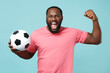 © ViDi Studio - Screaming african american man guy football fan in pink t-shirt isolated on blue background. Sport family leisure lifestyle concept. Cheer up support favorite team with soccer ball, clenching fist.